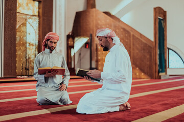 A group of Muslims reading the holy book of the Quran in a modern mosque during the Muslim holiday of Ramadan