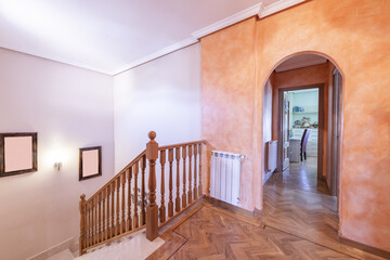 Stairs of a detached house with cream marble stairs and wooden railing