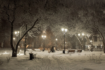 Snow-covered city square illuminated by night lights