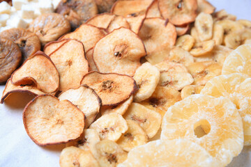 Different tasty dried fruits on paper, closeup