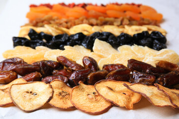 Different tasty dried fruits on paper, closeup