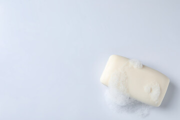 Soap with fluffy foam on white background, top view