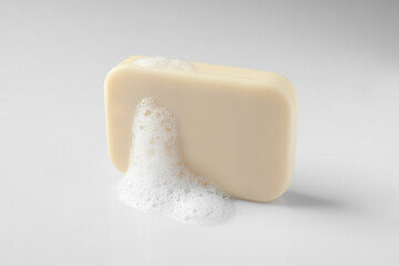 Soap with fluffy foam on white background