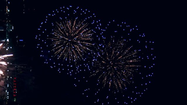 Loop seamless of real fireworks lights up the sky with dazzling displays in the night sky. Vertical Footage