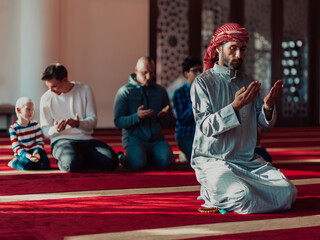 A group of Muslims in a modern mosque praying the Muslim prayer namaz, during the holy month of Ramadan