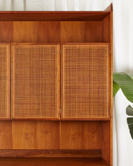 Vintage cane front cabinet. Minimalist hutch with drawers. Close-up detail with woven cane doors.
