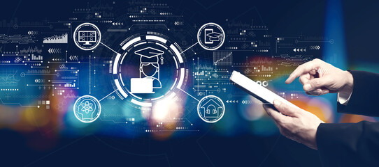 Distance learning theme with businessman using a tablet computer at night