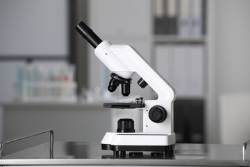 Modern medical microscope on metal table in laboratory