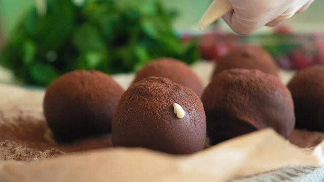 Glazed chocolate truffles on wooden background. Pouring white chocolate glaze on chocolate truffles. Domestic confectionery. Food dessert background. Bakery and pastry shop concept. cook cuts a potato