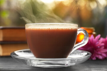 Glass cup with coffee on wooden table, closeup. Morning ritual
