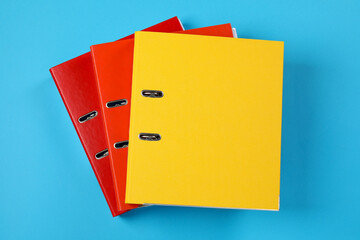 Many office folders on light blue background, flat lay