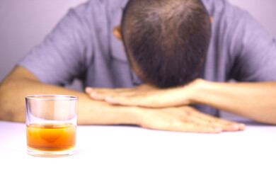 Glasses of whiskey and background images are male headaches. The result of excessive alcohol consumption.
