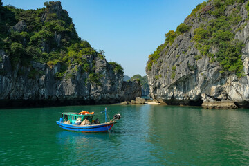 Fototapeta na wymiar Cat Ba, Vietnam - December 21, 2022: A fishing boat in Lan Ha Bay in Cat Ba, Vietnam.