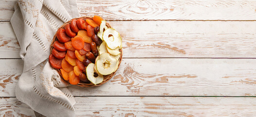 Tray with dried fruits on white wooden background with space for text