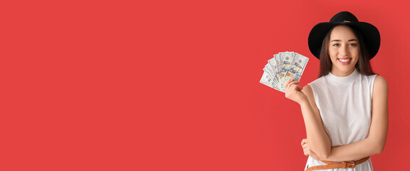 Happy young woman holding dollar banknotes on red background with space for text