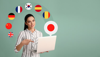 Young woman with laptop choosing to studying Japanese language on color background