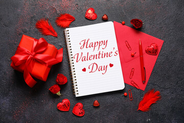 Romantic composition for Valentine's Day with notebook, gift and envelope on dark background