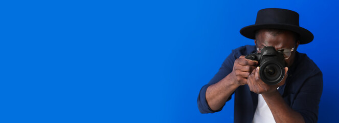 African-American photographer on blue background with space for text