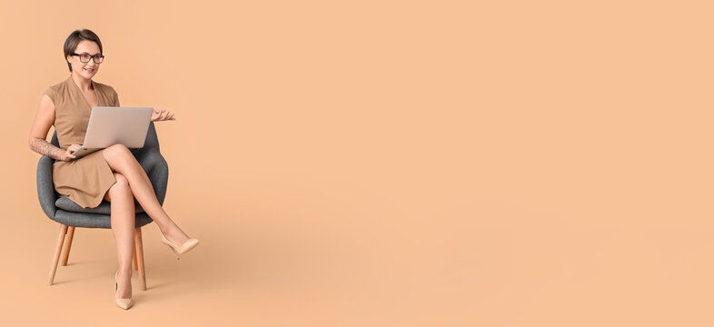 Portrait of female psychologist with laptop sitting in armchair on beige background with space for text