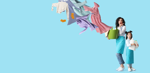 Fototapeta na wymiar Surprised mother and daughter with flying dirty clothes and detergents on blue background. Banner for design