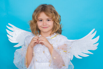 Kid wearing angel costume white dress and feather wings. Innocent child. Little angel on isolated studio background.