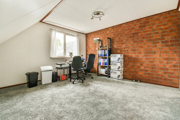 Naklejka premium a room with a brick wall and an office chair in the corner, next to a computer on a desk
