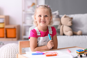 Cute little girl drawing with felt-tip pen at home