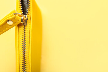 Cosmetic bag with metal zipper on yellow background, closeup