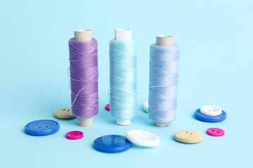 Sewing thread spools and different buttons on color background
