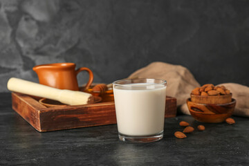 Glass on healthy almond milk on dark background