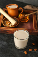 Glass on healthy almond milk on dark background