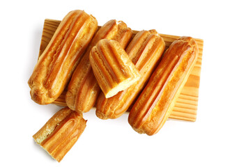 Wooden board with delicious eclairs isolated on white background