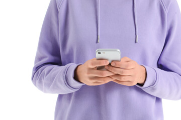 Young woman in hoodie using mobile phone on white background, closeup