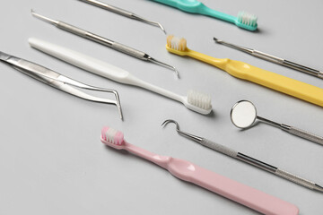 Dental tools with toothbrushes on grey background, closeup