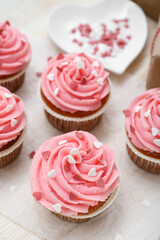 Baking paper with cupcakes for Valentine's Day on wooden background, closeup