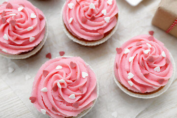 Baking paper with cupcakes for Valentine's Day on wooden background, closeup