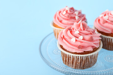 Glass stand with cupcakes for Valentine's Day on blue background, closeup
