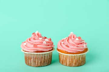 Tasty cupcakes for Valentine's Day on green background
