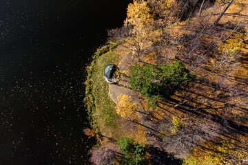 Aerial view of an autumn park surrounded by a pond and a park gazebo on the shore, autumn park...