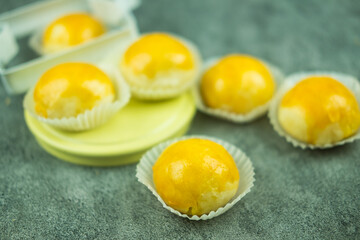 Chinese pastry or moon cake filled with mung bean paste and salted egg yolk in paper cups.