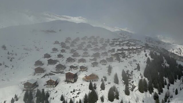 Chalets and mountain huts on Belalp behind a cloud. Beautiful weather but the settlement is in a clock cloud