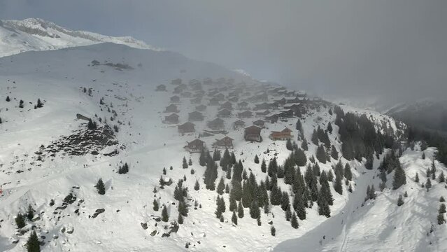 Chalets and alpine cabins on Belalp behind a cloud. Beautiful weather but the settlement is in a clock cloud
