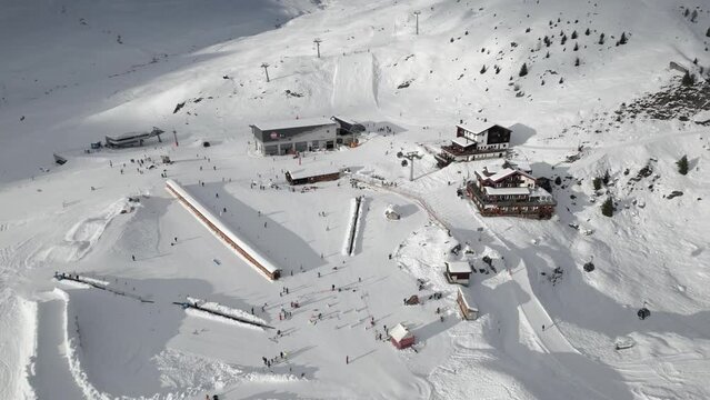 A ski resort in the mountains with gondola, chairlift, children's ski school and cottages as an aerial view. Belalp in the canton of Valais