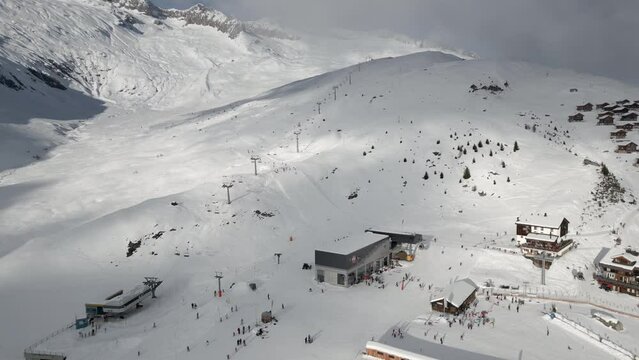 The Belalp ski resort in the canton of Valais in Switzerland. Skiers skiing down the slope. Clouds in the sky. Chairlift and gondola