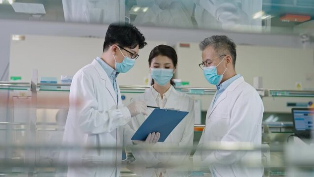 Three Chinese researchers discussing in laboratory,4K