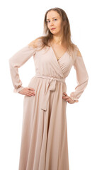 Fototapeta premium Amazing luxurious seductive woman in a stylish beige dress posing on a white background. natural makeup, loose hair. Fashionable portrait. Birthday celebration. isolated