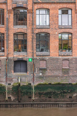 Vertical photo of red brick building on docks with number 1 sign on it