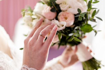 Obraz na płótnie Canvas bride's hand with a wedding ring on a wedding bouquet
