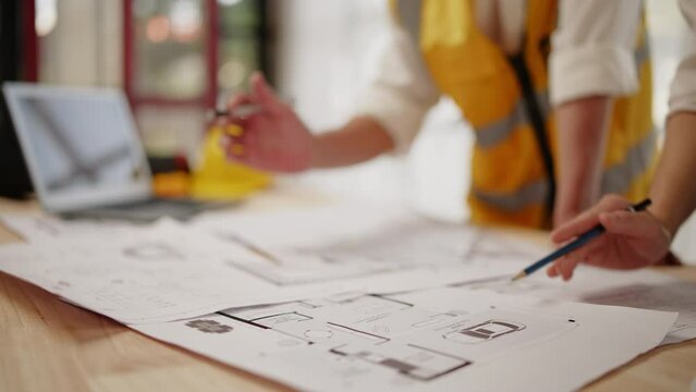 Closeup of hands engineer and architect team discussed about design construction and architectural drawings works within office.