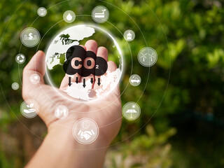 Reduce CO2 emission concept. Hand holding the earth with icons to help reducing the carbon dioxide in the air. Environmental, global warming, Sustainable development, and green business.